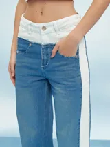 Pantalón de jean azul con cintura blanca y raya blanca lateral.