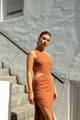 Vestido largo color ladrillo, de un solo hombro, con abertura cut-out en la cintura y falda irregular con frunces.