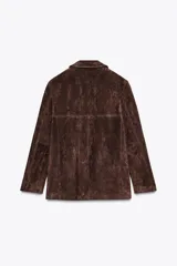 Blazer marrón de piel de ante, con cuello solapa, manga larga, bolsillos con solapa en el delantero y forro interior combinado.