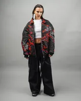 Campera reversible negra con estampado abstracto en rojo y blanco, de corte amplio y cuello camisero.