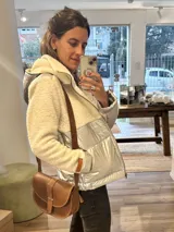 Campera con parte superior de paño de lana color crema y parte inferior impermeable plateada. Forrada con peluche y capucha desmontable.