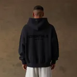 Hoodie oversize color negro con bolsillo frontales y etiqueta de goma en la capucha, confeccionado en mezcla de algodón y poliéster.