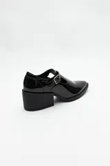 Zapato tipo T-bar de charol negro con hebilla lateral y taco ancho.
