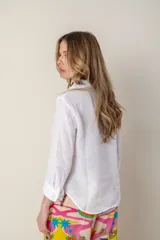 Camisa blanca de lino con cuello clásico, abotonada al frente y mangas 3/4 con puños.