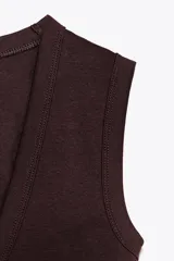 Camiseta negra de corte ajustado (slim fit) con escote pico pronunciado y manga sisa.