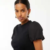 Camiseta negra entallada de tejido de punto acanalado, con cuello redondo y mangas cortas abullonadas de tela lisa.