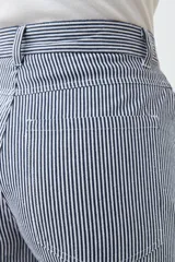 Pantalón de jean a rayas verticales azules y blancas, de corte amplio y tiro alto.