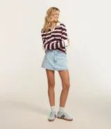 Short pollera de jean celeste con tiro alto, bolsillos delanteros y traseros, y trabillas en la cintura.