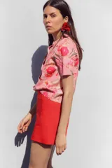 Bermuda roja de tiro alto con bolsillos delanteros de vivo y cierre lateral con cremallera oculta.