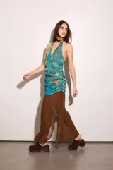 Vestido largo celeste con estampado abstracto multicolor, escote halter pronunciado, espalda baja y drapeado en la cadera. Incluye lazo para atar en el vestido o usar como bufanda.