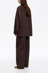 Pantalón jogger marrón de corte recto y tobillero, con tiro bajo, bolsillos alforja y cintura ajustable con cordón.