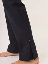 Pantalón de vestir color marrón, corte cigarette (pierna angosta) con tajo en el bajo. Presenta una cintura elástica ancha de color beige claro.