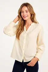 Camisa color crema de algodón, corte holgado, con cuello mao y cierre frontal con botones.