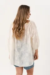 Blusa color crudo con bordado de flores, escote cuadrado y mangas 3/4 abullonadas.