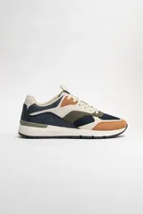 Zapatillas deportivas acordonadas con capellada de cuero sintético color beige, detalles en azul marino, verde oliva y marrón. Suela blanca con base negra.