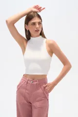 Top blanco de punto canalé, ajustado al cuerpo y con cuello alto.