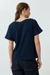 Remera verde oliva con escote en V, manga corta con dobladillo y cierre frontal con botones.