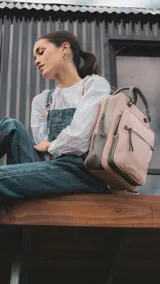 Mochila combinada en tres tonos de símil cuero: marrón, beige y negro. Tiene doble bolsillo frontal, asa de mano y correas regulables. En su interior tiene dos bolsillos con cierre y uno abierto con división para celular.