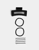 Set de accesorios para el pelo color negro, incluye un broche rectangular, dos gomitas elásticas y cuatro horquillas.