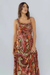 Vestido largo de seda de algodón estampada con detalles en hilo dorado, escote cuadrado con un bretel fino y otro ancho, tableado sutil en la parte delantera, lazo al costado y tajo.