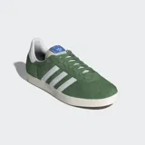 Championes de gamuza color verde con tres tiras blancas y suela de caucho, diseño clásico y ajuste cómodo.