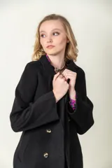 Tapado largo color camel, confeccionado en lana. Tiene doble botonadura, cuello con solapa y lazo para ajustar en la cintura.