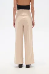 Pantalón de algodón y elastano color beige, de corte ancho y tiro alto.
