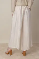 Pantalón palazzo color marfil, de viscosa, con cintura elastizada y cinto trenzado.