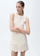 Vestido corto color crema, sin mangas, con cuello redondo y detalles calados en el cuello y ruedo.