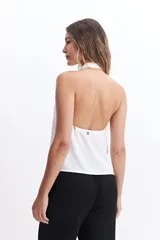 Musculosa blanca con detalle drapeado, cuello bote y espalda descubierta.