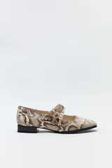 Zapato tipo Mary Jane color negro con textura de reptil, de charol sintético con punta cuadrada y triple tira con hebillas.