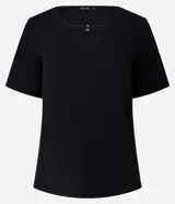 Blusa negra de crepé con cuello en V y mangas cortas. El cuello posee una tira horizontal unida por una pequeña hebilla metalizada.