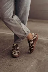Zapatillas bajas de cuero color marrón con suela de goma color caramelo y cordones marrones.