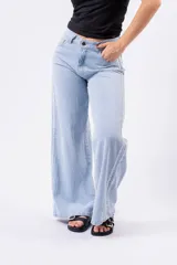 Pantalón de jean celeste de tiro alto, corte wide leg y largo completo. Presenta costuras decorativas en contraste a lo largo de las piernas.