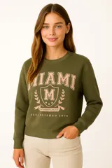 Buzo negro de cuello redondo y manga larga, con estampado frontal de la palabra "PARIS" en color lila con borde blanco.