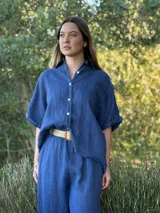 Camisa marrón de lino con botones blancos, corte holgado y mangas cortas.