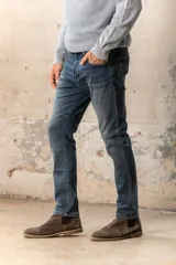 Pantalón de jean de corte recto, color azul medio, con bolsillos delanteros y traseros.