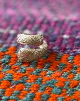 Anillo dorado con diseño de serpiente enroscada.