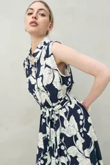 Vestido midi sin mangas confeccionado en viscosa fluida, con cuello camisero, estampado abstracto en negro y beige, y lazo para ajustar en la cintura.