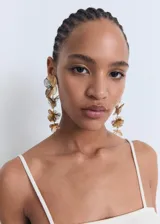 Top corto color crema, sin mangas y con tirantes finos. Presenta un diseño con volante fruncido en el escote y el bajo.