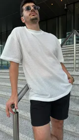 Remera blanca de tejido con punto semi abierto y cuello de ribb, calce oversize.