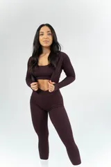 Conjunto deportivo color borgoña, compuesto por calzas largas de tiro alto, top con breteles finos y campera corta con cierre frontal y mangas largas.