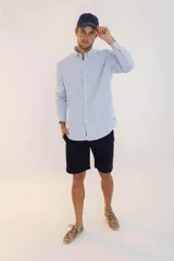 Camisa de hombre color crema, de corte clásico, con cuello abotonado y mangas largas.