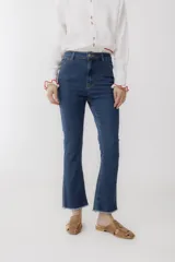 Pantalón jean cropped azul con corte acampanado y ruedo desflecado.