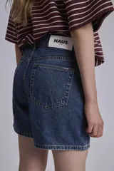 Bermuda de jean azul oscuro, tiro alto y corte a la rodilla.