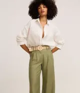 Pantalón wide leg verde oliva de cintura alta, confeccionado en viscolino, con trabillas en la cintura, cierre tradicional y pliegues. Incluye cinturón de rafia artificial.