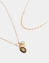 Collar corto dorado multicadena con eslabones de distintos grosores y dijes místicos con piedra ojo de tigre, corazón y letra C con strass.