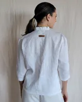 Camisa blanca de mangas 3/4 con cuello mao y botones frontales.