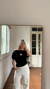 Remera negra de algodón con cuello bote y escudo de Uruguay bordado en dorado.