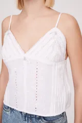 Musculosa blanca de breteles finos con detalles de encaje en el escote y bordado calado en el cuerpo.